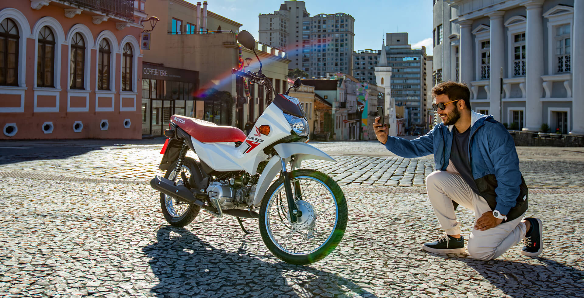 homem-tirando-foto-da-motocicleta-pop-110i-es